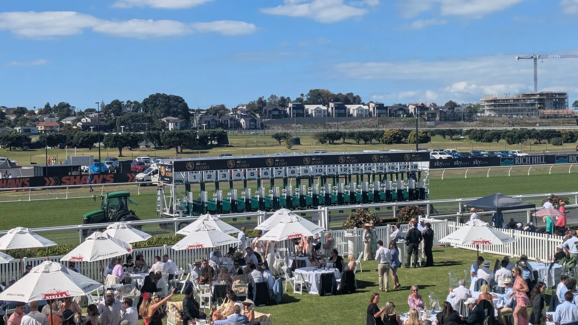 エラズリー競馬場のコースに置かれたスターティングゲートと、手前の芝生エリアの観客
